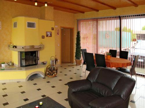 un soggiorno con divano, tavolo e camino di Holiday Home Zum Katzengrund I by Interhome a Hinrichshagen