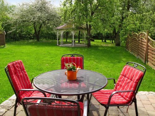 tavolo con quattro sedie rosse e gazebo di Holiday Home Zum Katzengrund I by Interhome a Hinrichshagen
