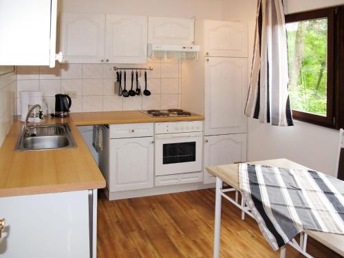 ヒンメルプフォルトにあるHoliday Home Waldhäuser-1 by Interhomeの白いキャビネットとシンク付きのキッチン