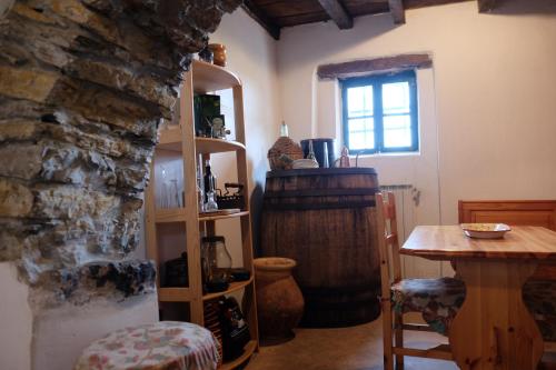 sala de estar con mesa y pared de piedra en Agriturismo Il glicine e la lucerna - Appartamento Scala en Ranzo-Borgo