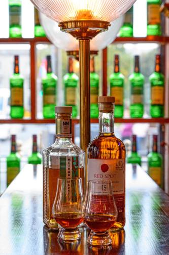 two bottles of alcohol sitting on a table with a lamp at Thirteen On The Green - Eyre Square in Galway