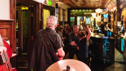 a group of people standing in a bar at Thirteen On The Green - Eyre Square in Galway