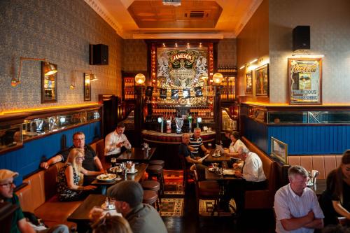 a group of people sitting at tables in a restaurant at Thirteen On The Green - Eyre Square in Galway