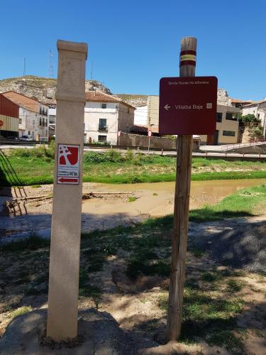 two signs on a pole next to a street at Casa Rural Casa Clemen in Villalba Baja