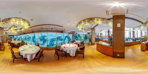 ein Restaurant mit Tischen und Stühlen und einem großen Aquarium in der Unterkunft Tea Boutique Hotel West Lake in Hangzhou