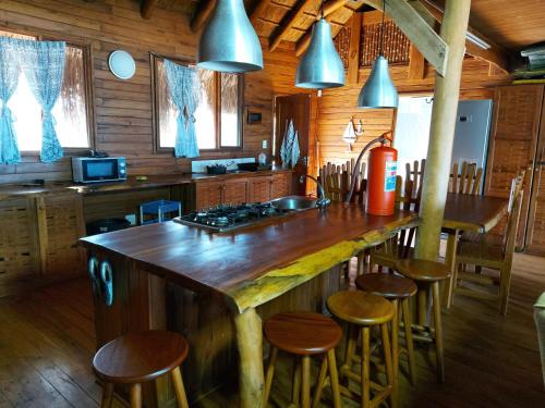 a kitchen with a large wooden island in a cabin at Chicuanga in Chizavane