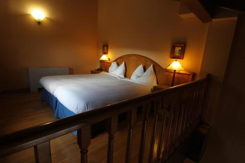 a bedroom with a bed with white sheets and two lamps at Cerdanya Viva Ecoestades in Prullans