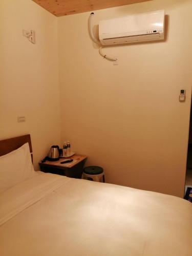 a bedroom with a bed and a air conditioner at mei hao min su in Nangan