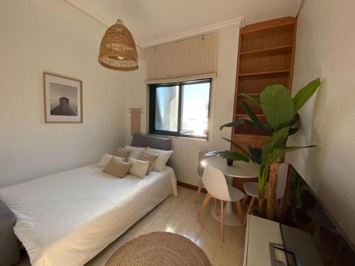 um pequeno quarto com uma cama e uma mesa em Samil55 em Vigo