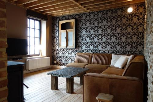 a living room with a couch and a table at Gîtes le second à Spa (gîte de 2 et de 5 personnes) in Spa
