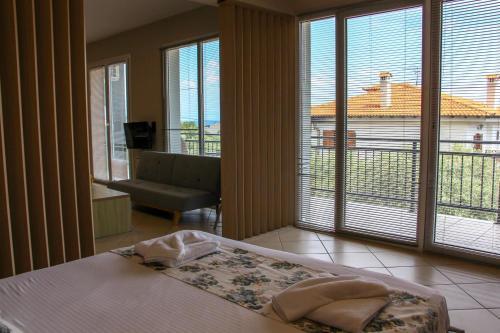 タソスにあるMirador Apartmentsのベッドルーム1室(ベッド1台付)、バルコニー(窓付)