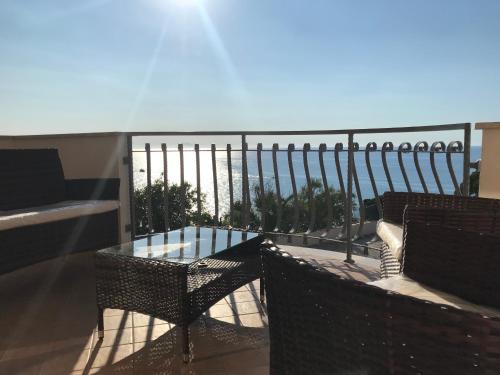 a balcony with two chairs and a glass table at Bonsai in Tropea