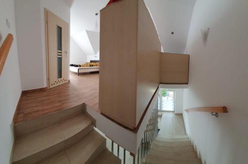 a staircase in a home with white walls and wooden floors at Domy szeregowe Klif in Pobierowo