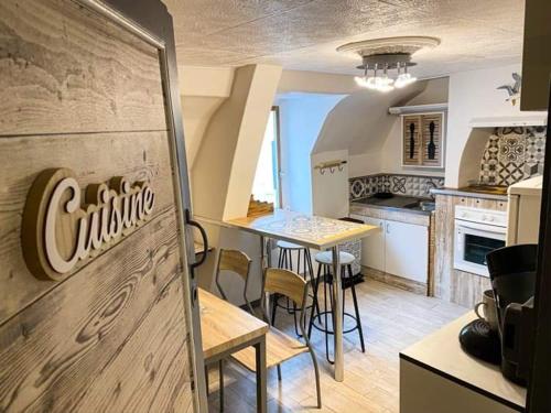 a kitchen with a table and chairs in a room at Les gites de Marie in Boulogne-sur-Mer