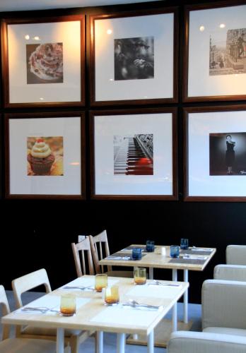 two tables in a restaurant with pictures on the wall at d'primahotel Tangerang in Tangerang