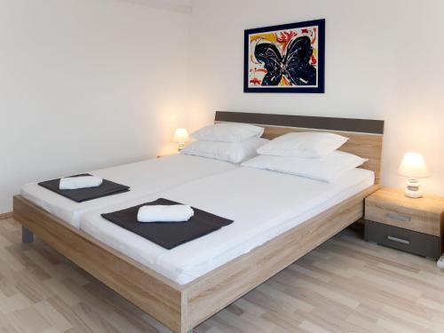 ein Schlafzimmer mit einem großen Bett mit weißer Bettwäsche in der Unterkunft Apartment Bacic - OMI216 by Interhome in Marusici 