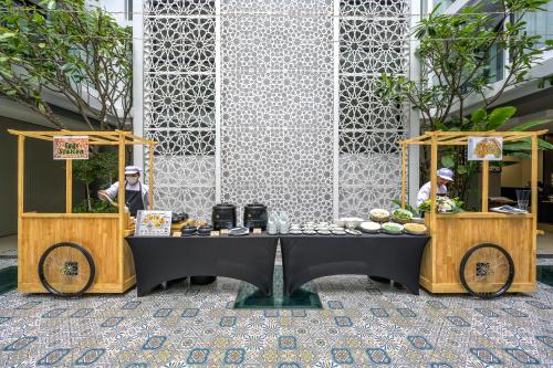 Zwei Personen stehen hinter zwei Tischen mit Essen darauf. in der Unterkunft Zenseana Resort & Spa - Patong, Phuket in Patong Beach