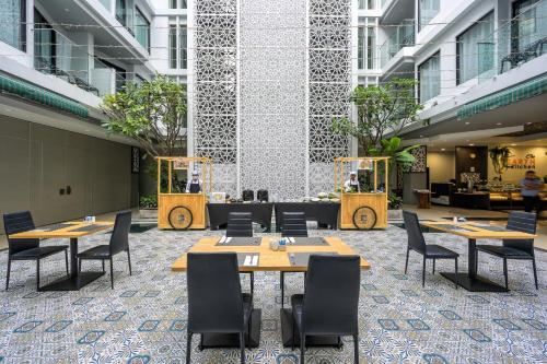 eine Cafeteria mit Tischen und Stühlen in einem Gebäude in der Unterkunft Zenseana Resort & Spa - Patong, Phuket in Patong Beach