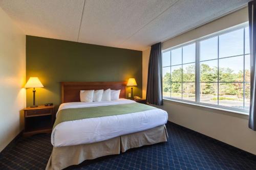 a hotel room with a bed and a large window at Quality Inn & Suites Conference Center West Chester in West Chester