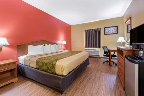 a hotel room with a bed and a desk at Econo Lodge Louisville Airport in Louisville