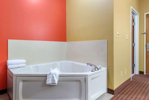 a bath tub in a bathroom with orange walls at Econo Lodge Louisville Airport in Louisville