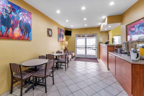 a restaurant with tables and chairs and a kitchen at Econo Lodge Louisville Airport in Louisville