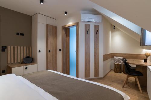 a bedroom with a bed and a desk and a table at Penzion Repanšek in Radomlje