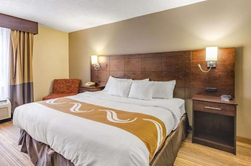 a hotel room with a large bed and a chair at Quality Inn Radford-West Blacksburg I-81 in Radford