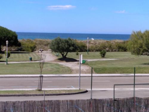 an empty street with the ocean in the background at Camping Playa de Ris in Noja