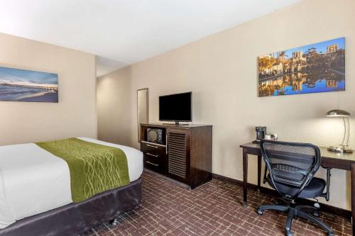 a hotel room with a bed and a desk with a computer at Comfort Inn San Diego Old Town in San Diego