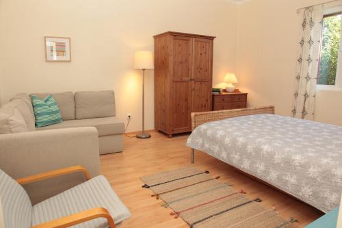 - un salon avec un lit et un canapé dans l'établissement Nagymajor Birding Lodge, à Tiszacsege
