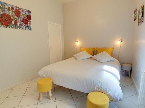 a bedroom with a large white bed with yellow accents at Stop Chez M Cozy # Qualité # Confort # Simplicité in Pierre-Bénite