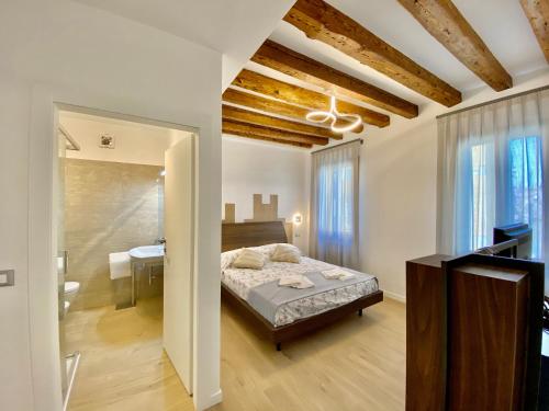 a bedroom with a bed and a bathroom with a sink at Suite House new apartments canal view Venice island in Venice