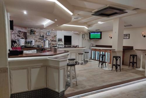 SonsecaにあるHOSTAL-CAFE GUTGRECOのスツール付きのバーとテレビが備わる客室です。