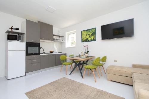 a kitchen and living room with a table and chairs at Apartmani kike in Makarska