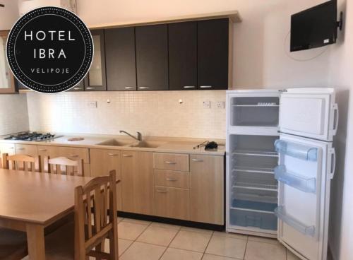 eine Küche mit einem offenen Kühlschrank und einem Tisch in der Unterkunft Hotel Ibra in Velipojë