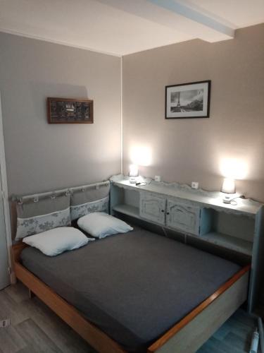 Ce lit se trouve dans un dortoir doté de 2 lampes murales. dans l'établissement studio au pied de la cathedrale notre dame, à Boulogne-sur-Mer