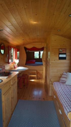 een blokhut met een keuken en een slaapkamer bij La Girardière in Le Boupère