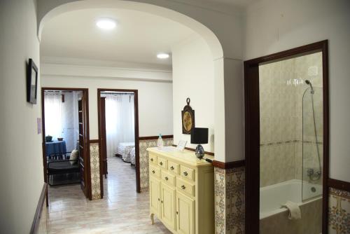 a bathroom with a shower and a yellow dresser at Flor da Primavera - Residencial e Apartamentos in Azambuja