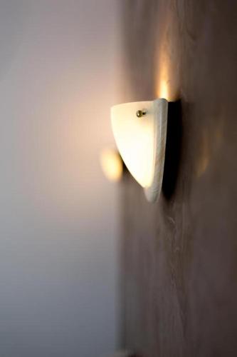 a white urinal on the wall of a bathroom at Hotel Alizéa in Avignon