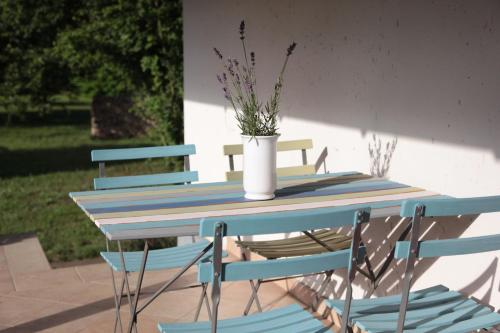 a table with chairs and a vase with flowers on it at Nagymajor Birding Lodge in Tiszacsege