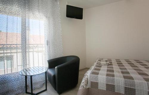 a room with a chair and a table and a window at Hotel Alizéa in Avignon