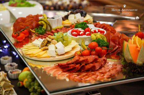 a buffet of cheese and meats and fruits and vegetables at Hotel Antunovic Zagreb in Zagreb