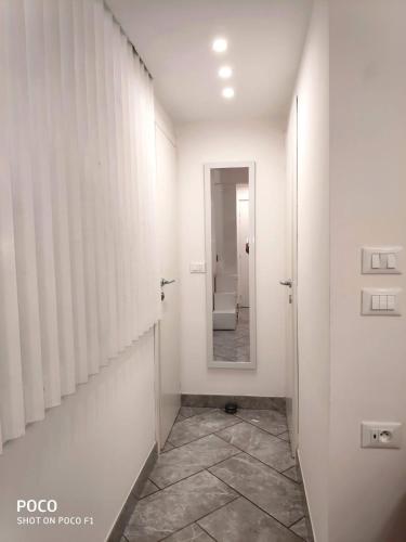 - un couloir avec une salle de bains pourvue de toilettes et d'un miroir dans l'établissement Logement de Catherine, à Nice