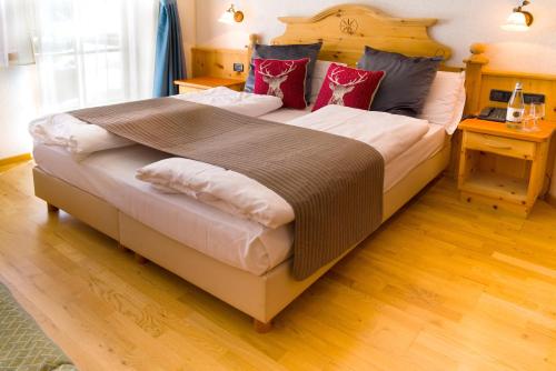 カナツェーイにあるHotel Villetta Maria Cottageのベッドルーム1室(大型ベッド1台、木製ヘッドボード付)