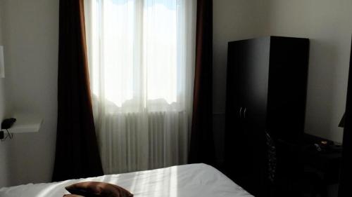une chambre avec un lit, une télévision et une fenêtre dans l'établissement Hôtel Saint George, à Avignon
