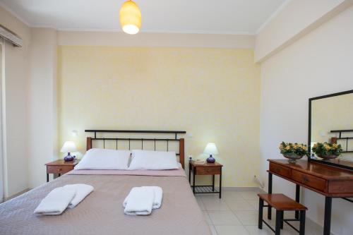 a bedroom with a large bed with two towels on it at Vasso Apartments 3 in Kissamos