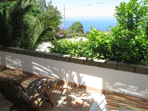 a patio with a bench and the ocean in the background at Villa Alba Appartamenti in Kamma