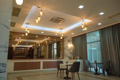 a restaurant with a table and chairs and a bar at Aqua Batumi Hotel & Apartments in Batumi