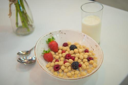 a bowl of cereal and berries on a table at Aqua Batumi Hotel & Apartments in Batumi